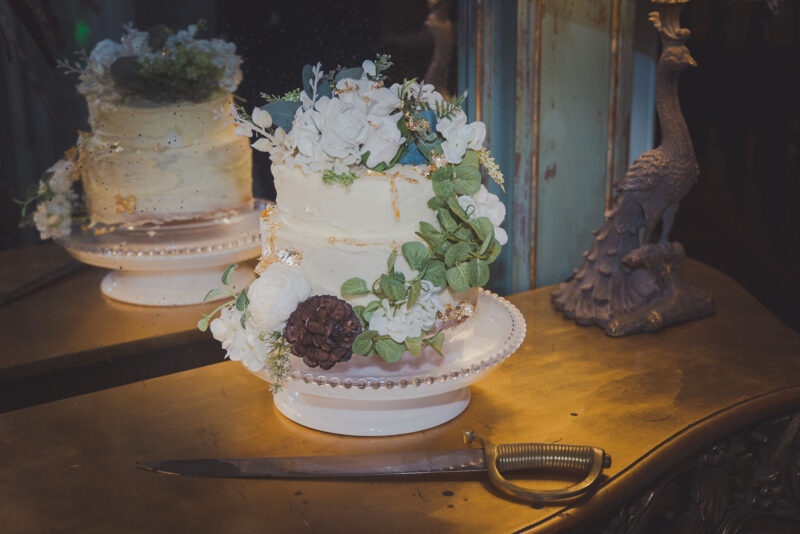 A documentary wedding photographer captures a wedding cake on a table in front of a mirror at West Lothian.