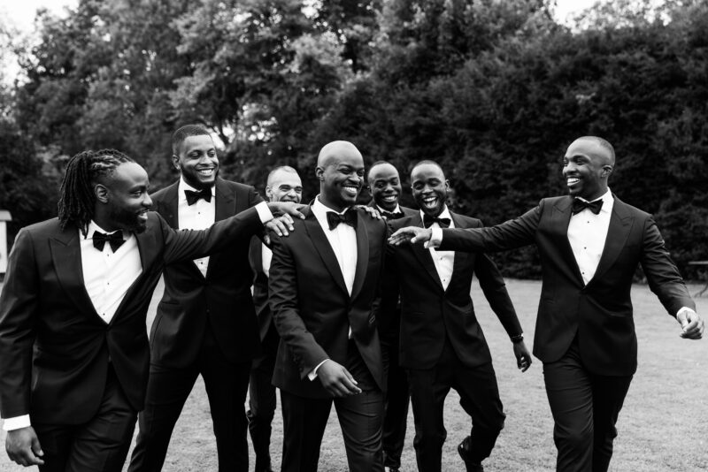A black and white photo of a group of groomsmen in tuxedos.