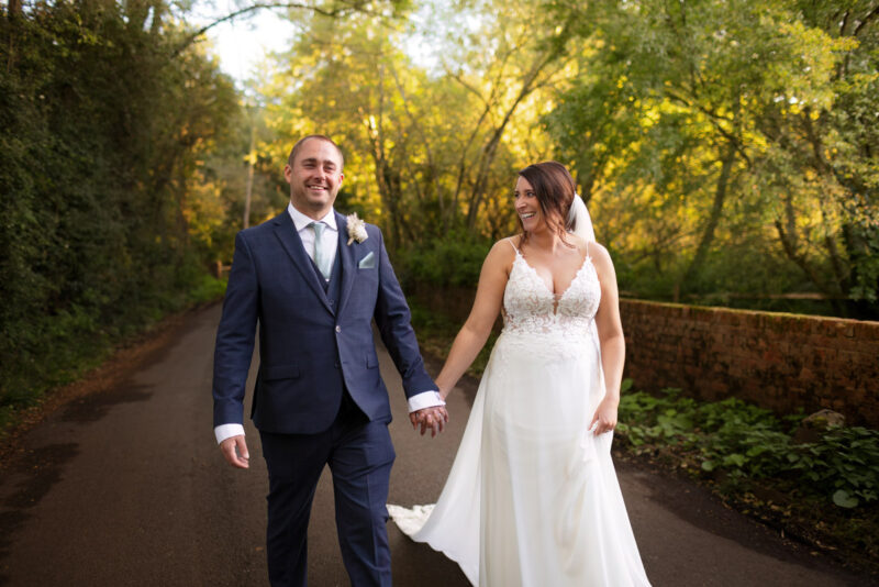 A bride and groom walking down a country road captured by a West London wedding photographer.
