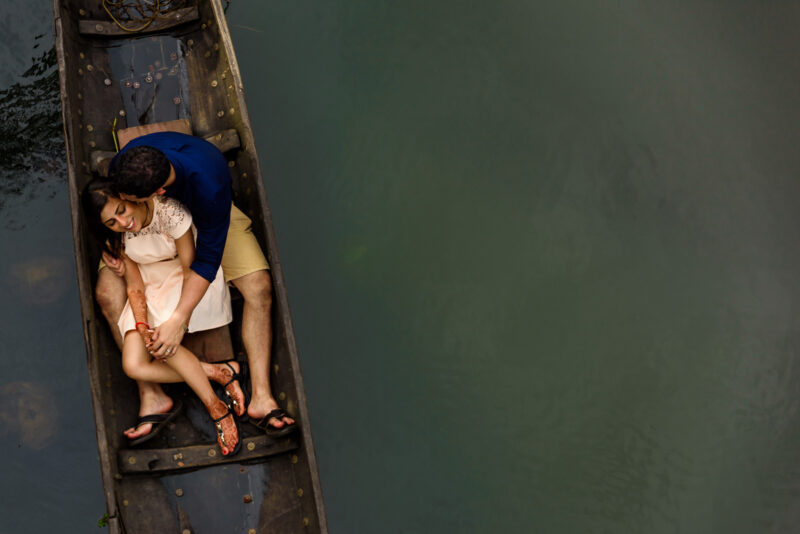 A couple sitting in a boat on a river.