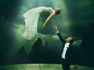 A man and woman in a wedding dress flying in the air.