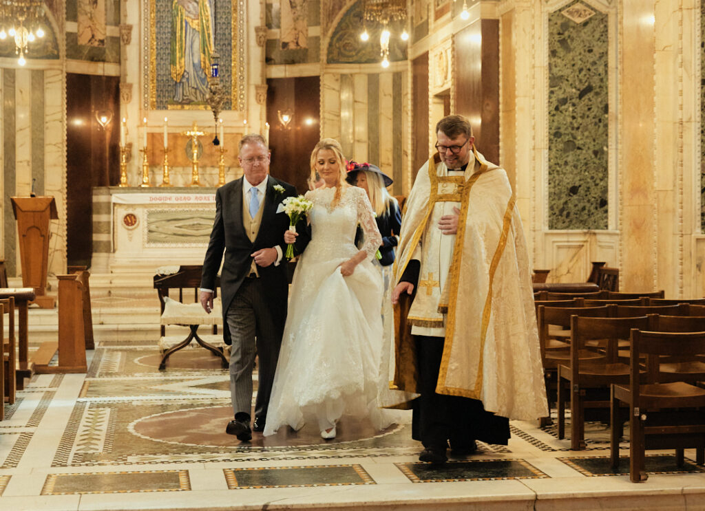 A bride and groom walking down the aisle of a church.