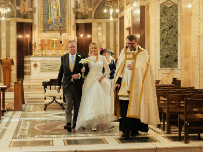 A bride and groom walking down the aisle of a church.