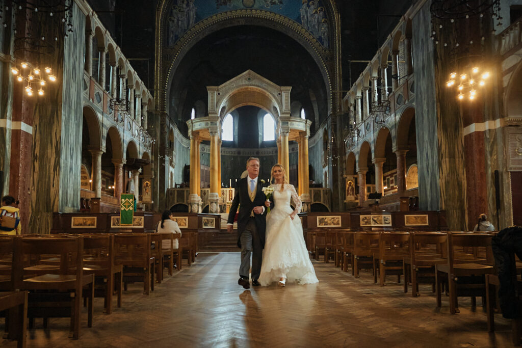 A bride and groom walking down the aisle of a church.